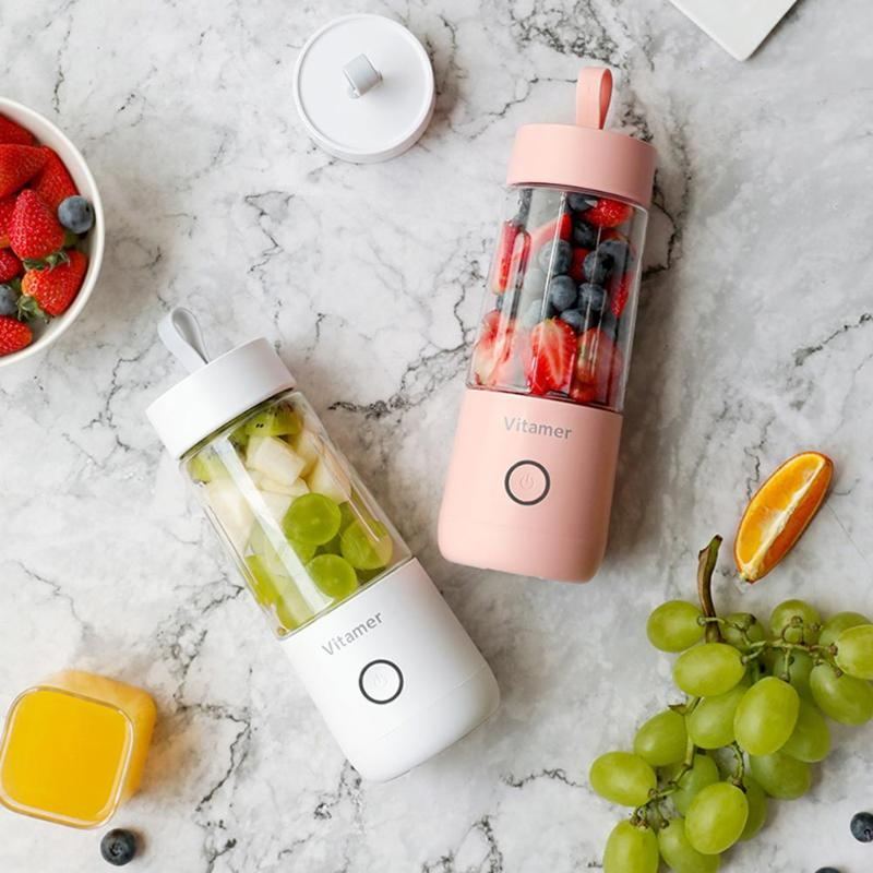 Vitamer rechargeable personal blender in pink and white with fresh fruit inside on marble surface
